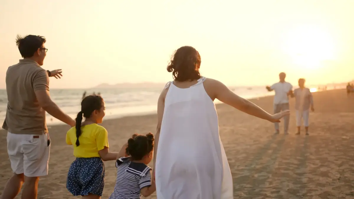 Happy big Asian family on beach holiday travel vacation. Multi-generation family enjoy outdoor lifestyle walking together on the beach at summer sunset.